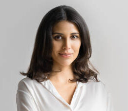 Isolated portrait confident middle eastern businesswoman, business lady standing with crossed arms on grey background. Young Arabian or latin woman in formal clothes looking at camera, copy space